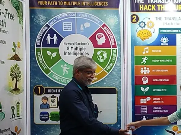 D. Arunkumar beside the Multiple Intelligences wheel at the guidance desk